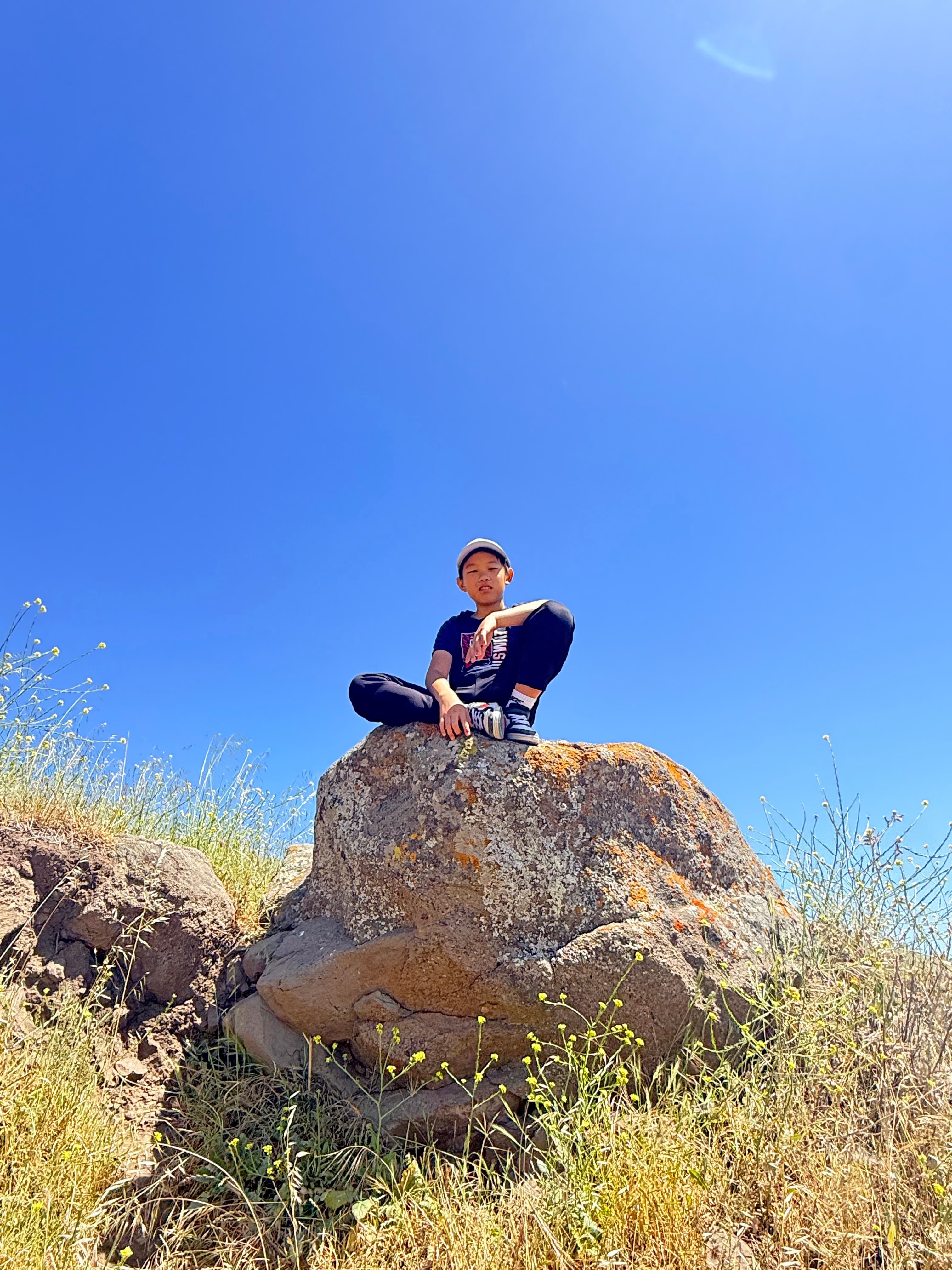 孩子坐在 Mission Peak 路边大石头上
